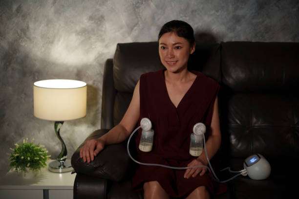 Woman using a double electric breast pump at home.
