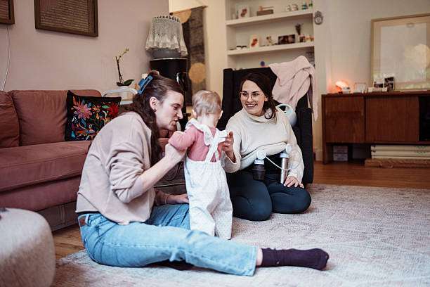 Mother using breast pump while tending to baby.