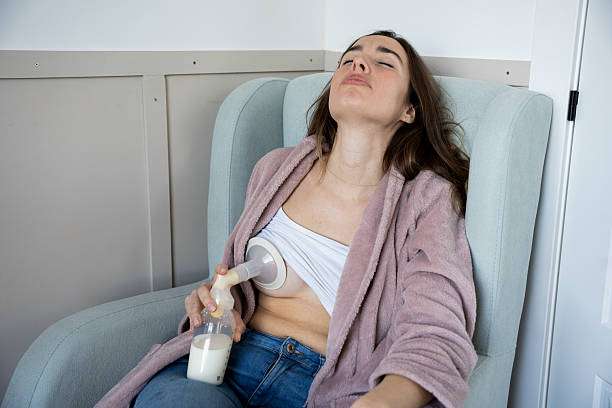 Woman relaxing in chair with breast pump