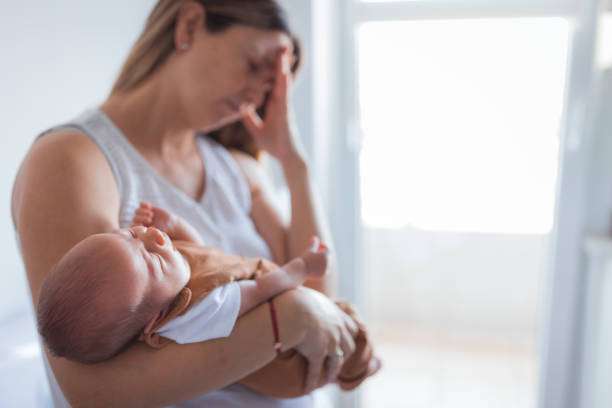 Stressed mother holding baby with breast pump considerations.