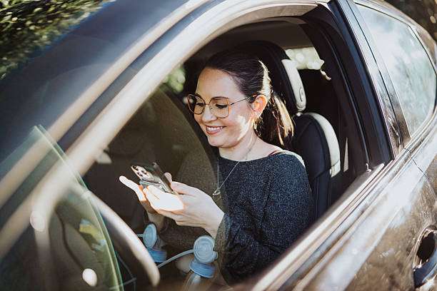 Woman smiling in car, using breast pump accessories.