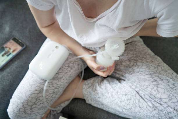 Overhead view of woman using a portable breast pump with bottle.