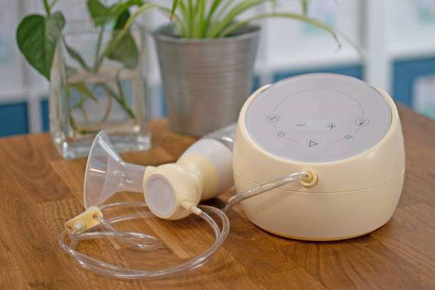 Modern breast pump unit and flange on a table.