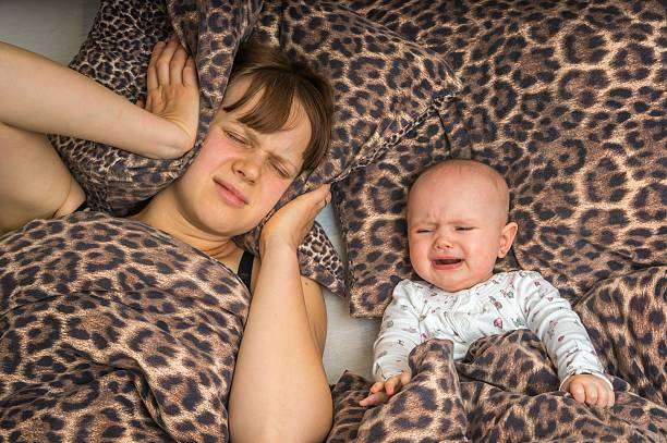 Tired mom and crying baby; a breast pump can offer flexibility for sleep.