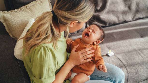 Mother comforts crying baby; a breast pump can help ensure milk supply.