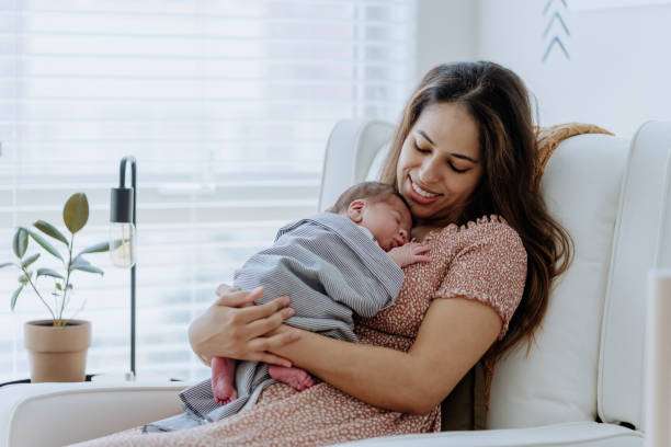 Happy mother holding her sleeping baby; a breast pump helps with feeding routines.